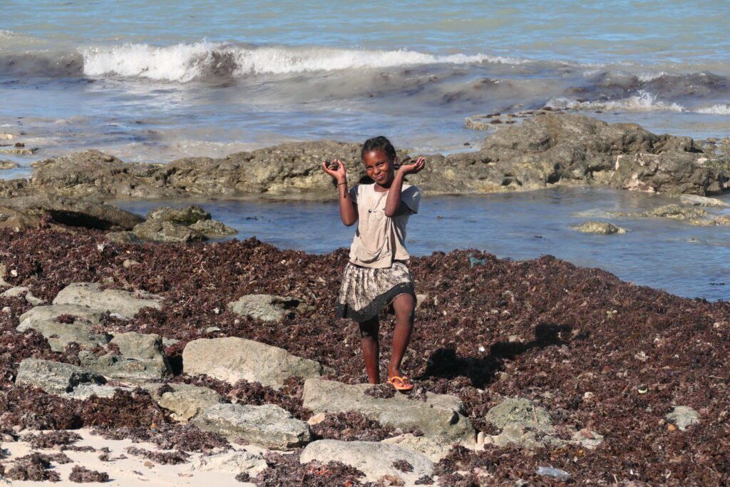 Girl collecting shells on the coast near northern Ifaty during the southwest Madagascar roundtrip with MadaPlus TRAVEL.
