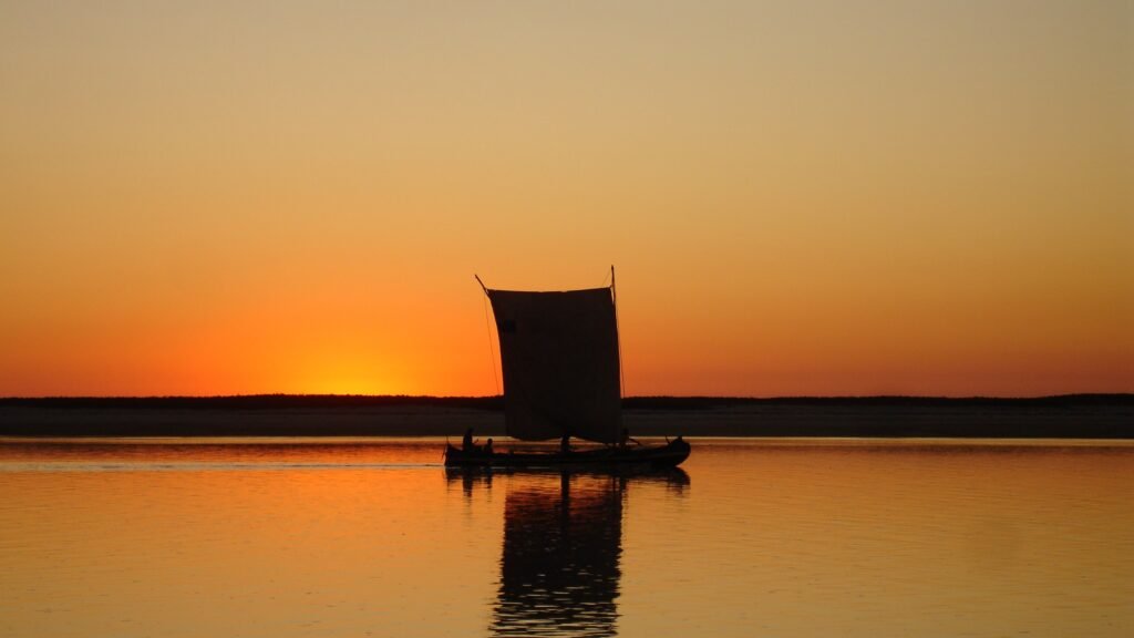 Traditionelle Szene am Strand von Morondava bei Sonnenuntergang – warmes Licht, Fischerboote und authentische Atmosphäre an der Westküste Madagaskars