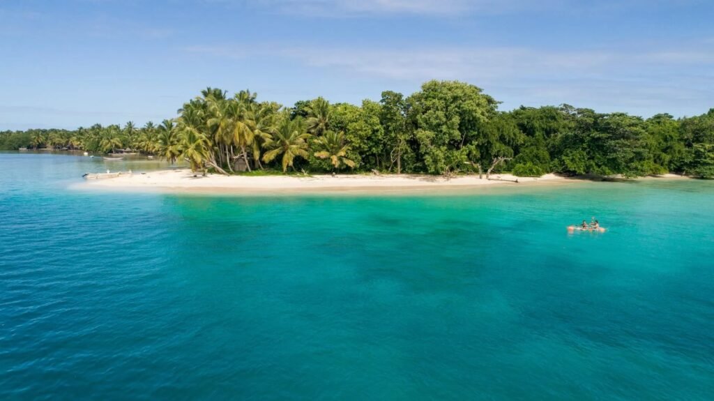 Bucht auf Sainte Marie mit türkisfarbenem Wasser, palmengesäumtem Sandstrand und einem Kajak.